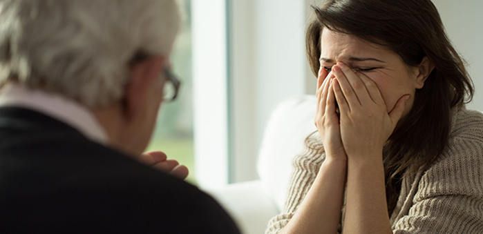 woman crying in front of an older man, indoors