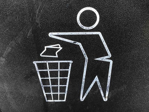 chalk white on black person cartoon throwing garbage in trash can