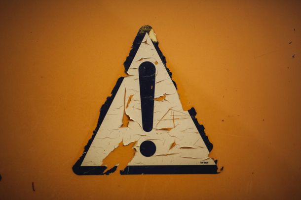 yellow attention sign falling apart
