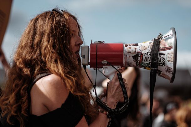 woman outside on a bullhorn talking to a group